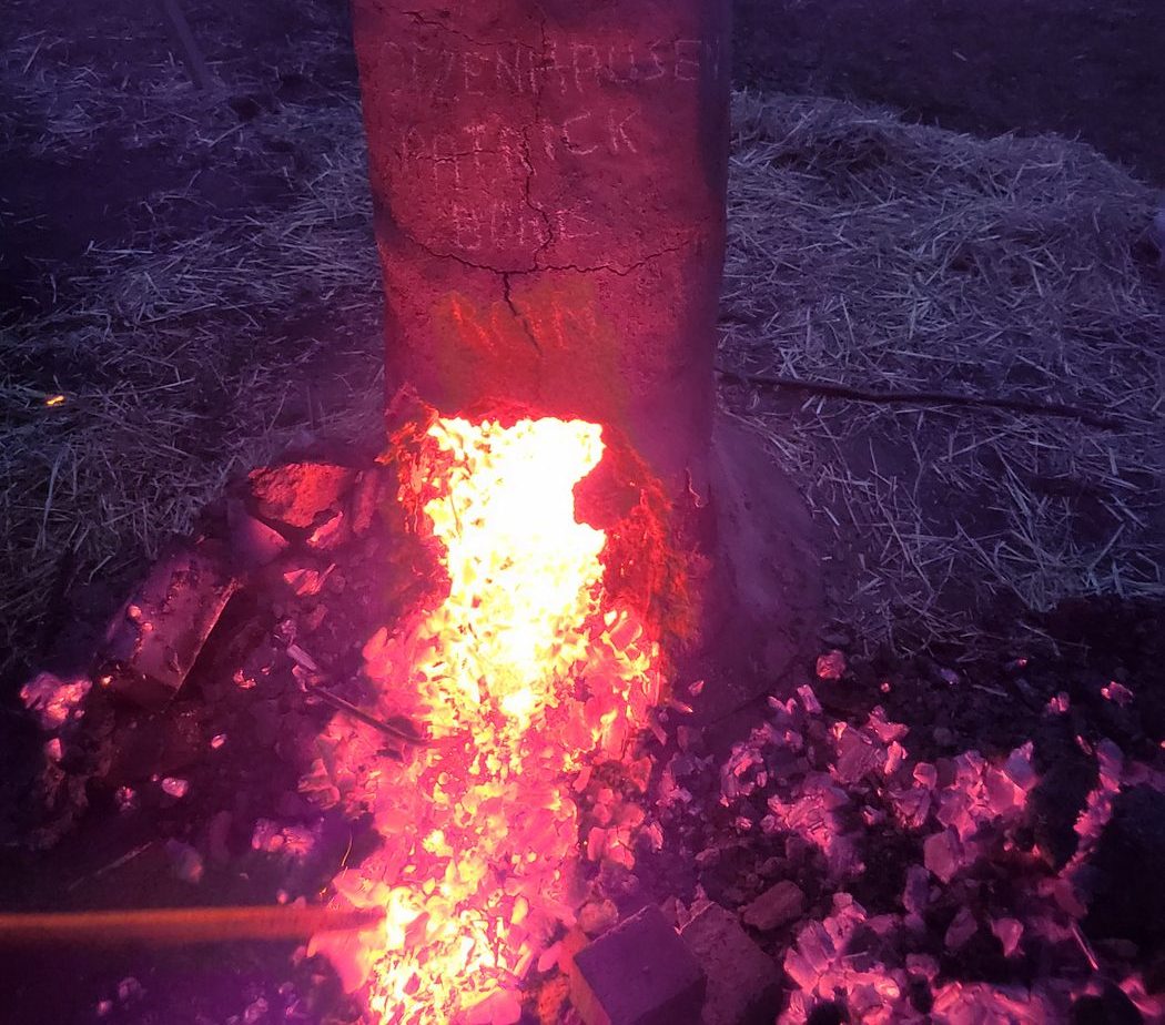 Rennofen bei Nacht mit glühender Verhüttung