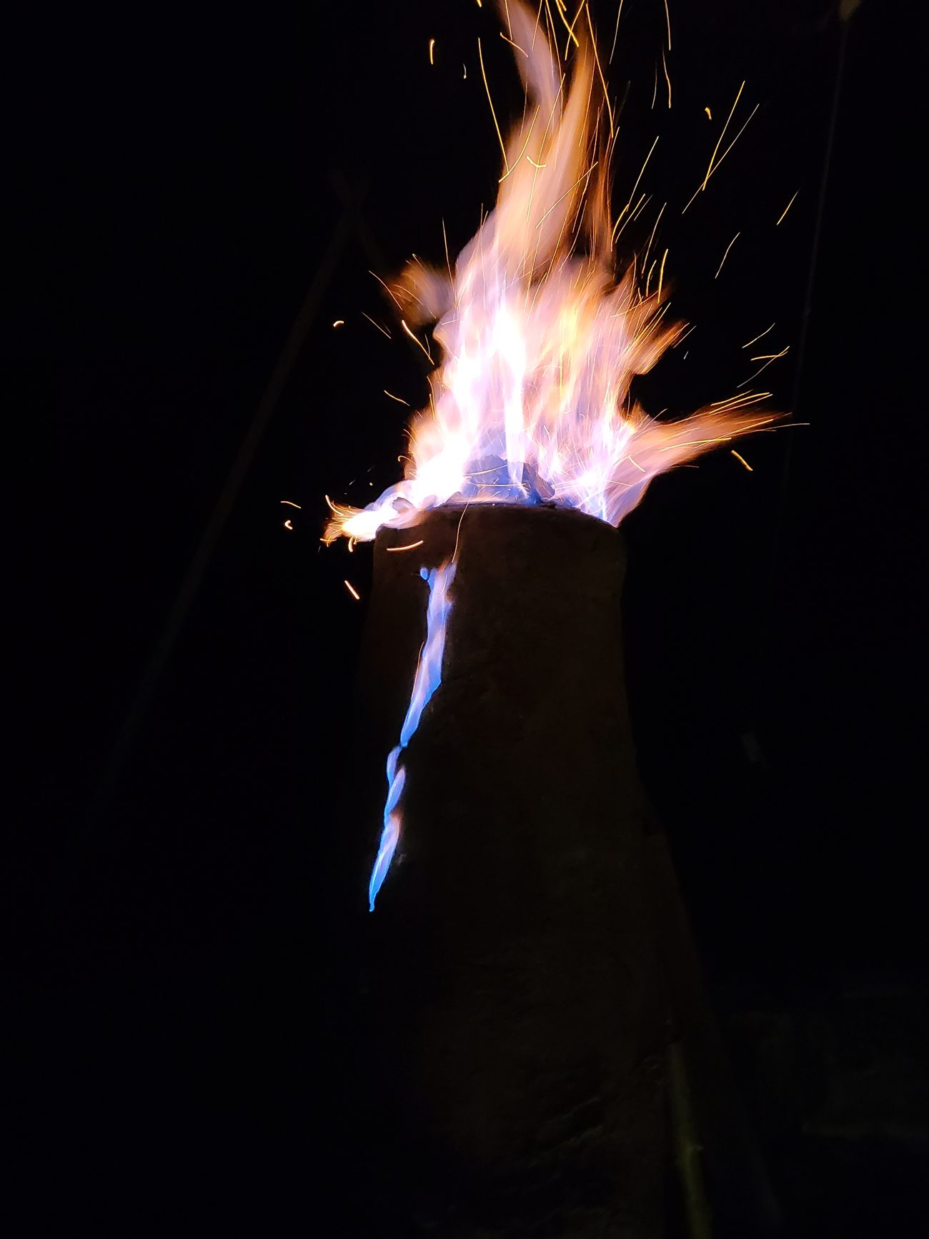 Gichtflamme über dem Rennofen bei Nacht während der Verhüttung